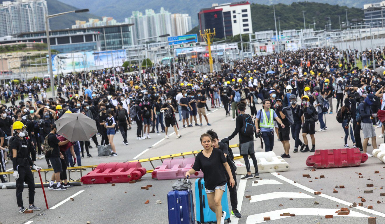 9月1日，在抗议者削弱了运输联系之后，旅客和航空公司机组人员被迫步行前往机场。照片：李小龙