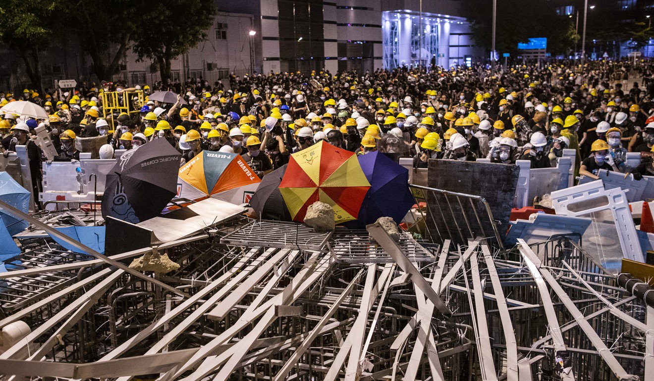 7月1日在香港舉行的抗議活動中，示威者聚集在一個街壘後面與防暴警察對峙。 