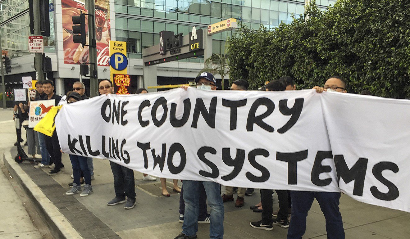 一群香港移民在洛杉磯貿易研討會的會場外抗議。照片：張家輝