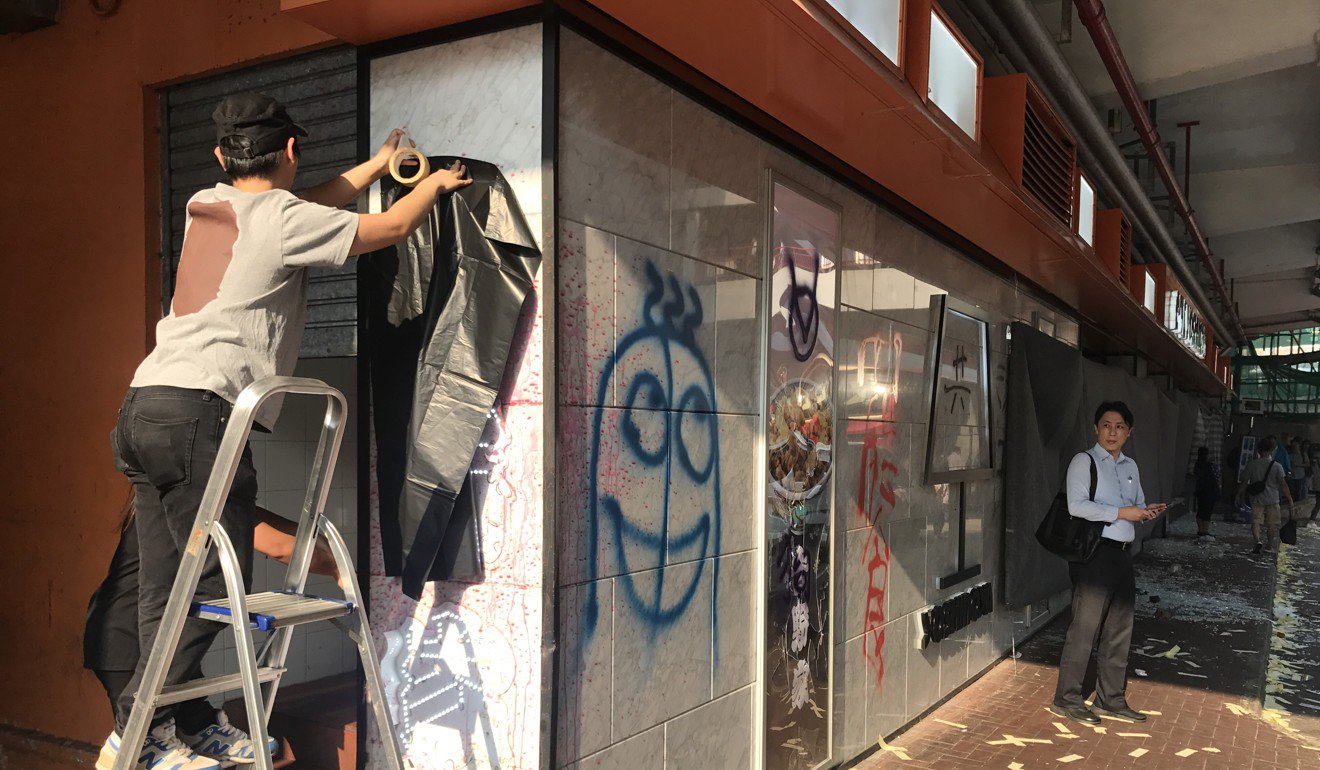 工人们掩盖了遍布荃湾吉野家分店的涂鸦。摄影：刘玉静