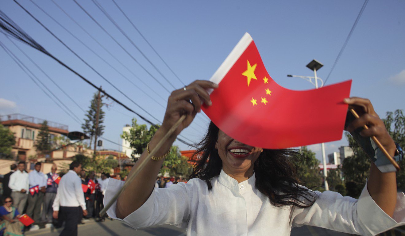 一名妇女挥舞着中国国旗欢迎习近平来到尼泊尔。图片：AP