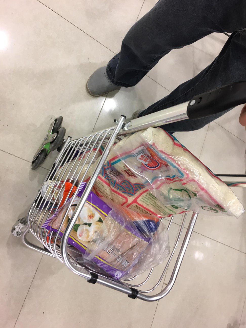一名本地居民在荃湾的百佳超级市场买了三袋共十五公斤的大米和一箱冷冻点心。照片：孙菲娜