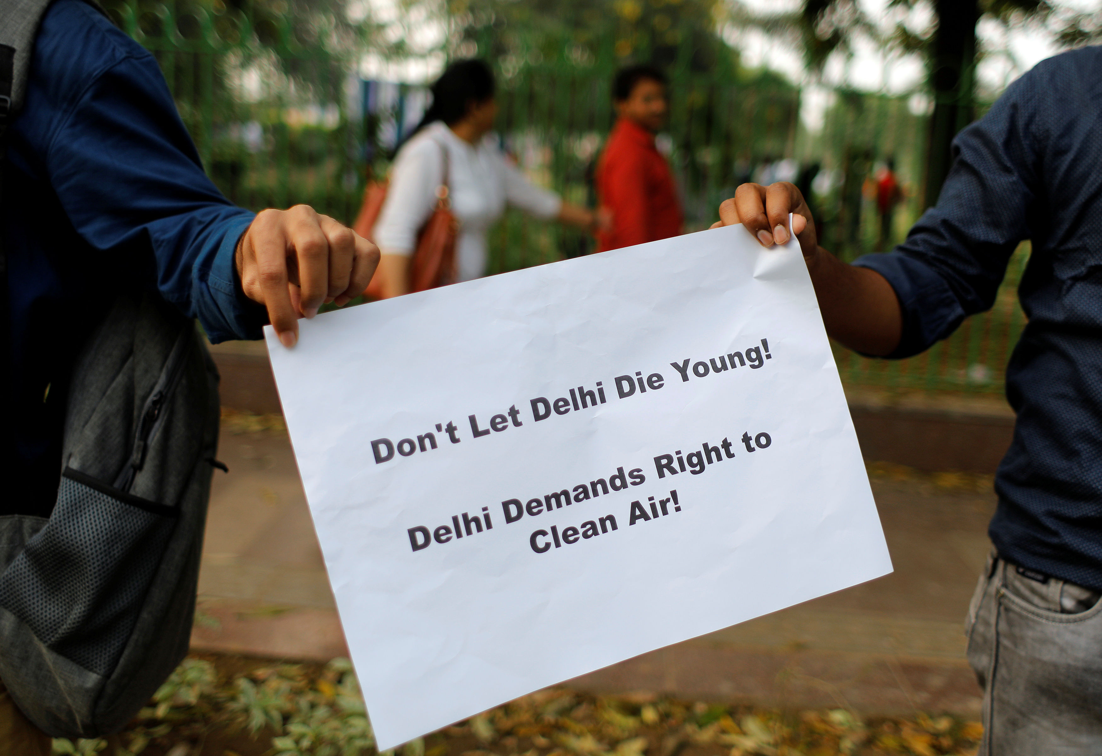 人們在組成人鏈時舉著標語牌，要求政府立即採取措施控制新德里的空氣污染（照片：路透社）
