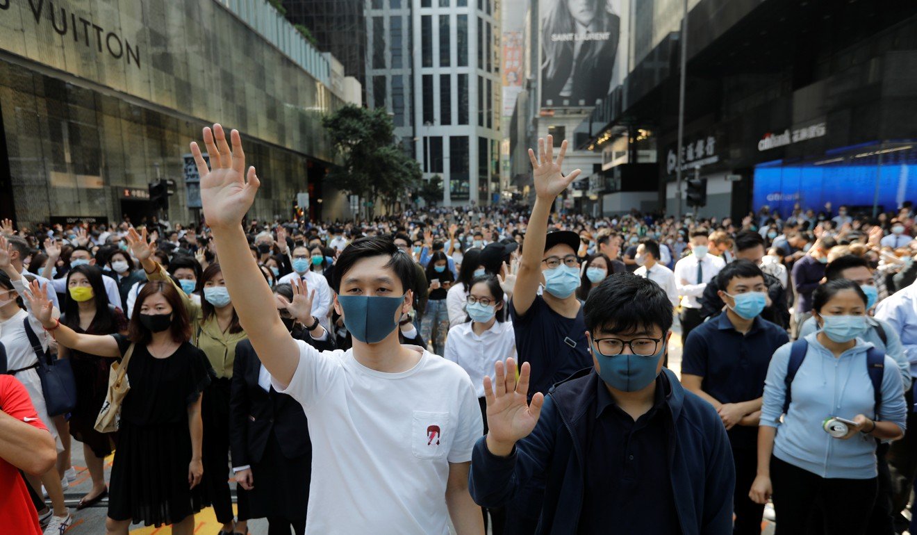 示威者在2019年11月15日在香港中区的抗议活动中上街时举手。照片：路透社