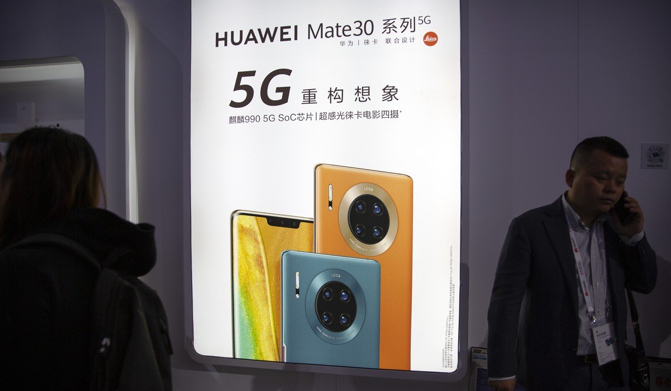 十月在北京舉行的PT世博會上，一位與會者在針對中國技術公司華為的廣告旁使用他的智能手機。華盛頓對中國實行以國家為主導的自有全球技術競爭對手的倡議持謹慎態度。照片：AP