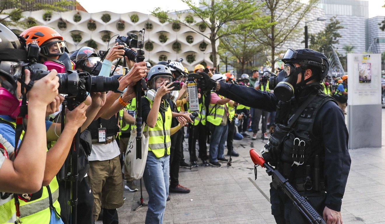 在香港的另一天，一名警官将胡椒喷雾剂对准似乎只包括记者的一群人，当警察在面对抗议时反复依靠防暴人员。照片：曾荫权
