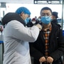一名医务人员在湖南省长沙市飞机场的候机楼取一个男人的体温。 （路透社）