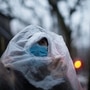 一名戴著口罩並用塑料袋覆蓋的男子在中國上海的一條街道上行走，當時該國正遭受新型冠狀病毒的爆發。 （路透社）