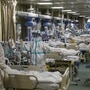 身穿防護服的醫務人員在湖北省武漢市一家指定醫院就診了新型冠狀病毒患者（照片：路透社）