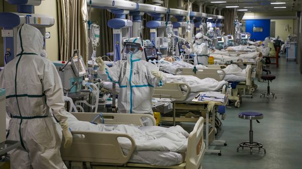 身穿防护服的医务人员在湖北省武汉市一家指定医院的重症监护室就诊新出现的冠状病毒患者