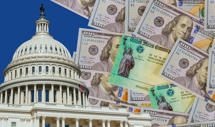 在华盛顿特区的国会大厦旁边的两个财政部支票和一堆凌乱的一百美元的钞票
